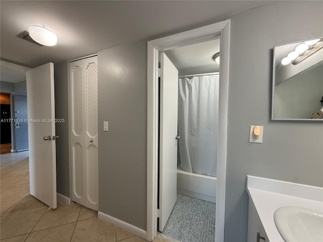 bathroom featuring tile patterned floors, shower / tub combo, vanity, and baseboards