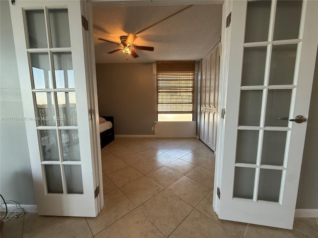 unfurnished room with light tile patterned flooring, a ceiling fan, french doors, and baseboards