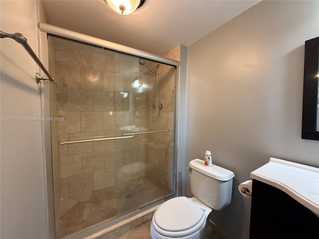 bathroom with toilet, a shower stall, and vanity