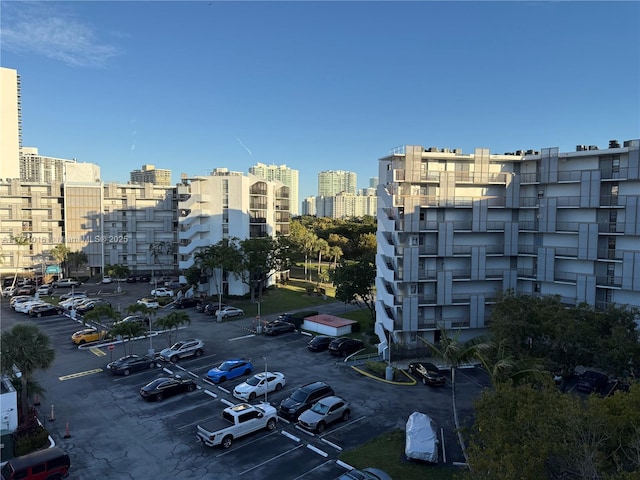 view of property with uncovered parking and a city view