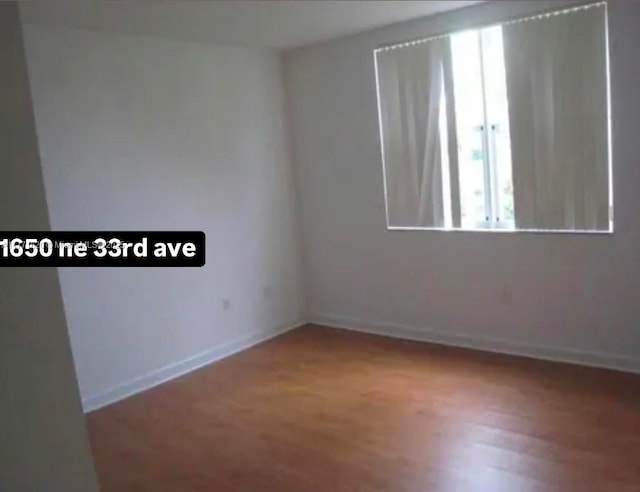 1650 NE 33rd Ave Unit 105-7, Homestead, FL 33033 - empty room featuring baseboards and wood finished floors