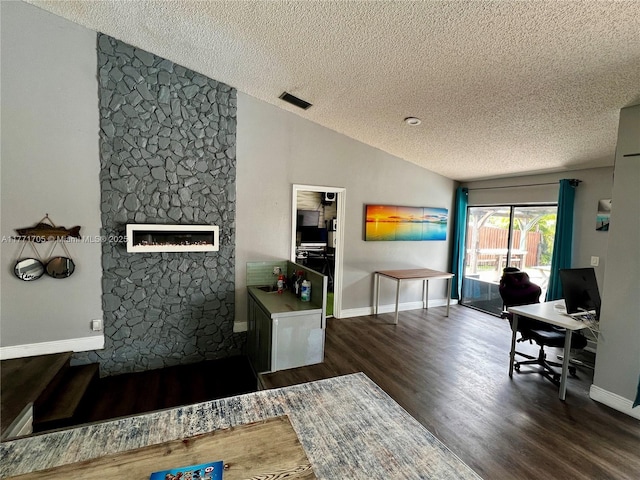 office with dark wood finished floors, vaulted ceiling, visible vents, baseboards, and a textured ceiling