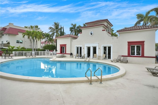 pool featuring fence, french doors, and a patio