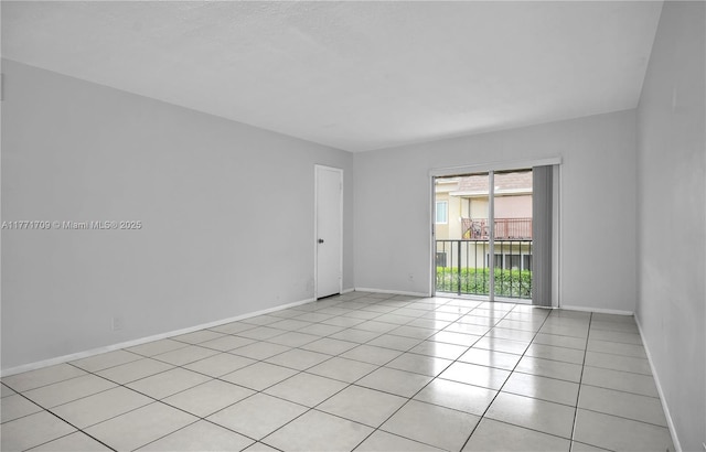 unfurnished room featuring light tile patterned flooring and baseboards