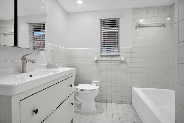 full bathroom featuring a bath, tile patterned floors, toilet, tile walls, and vanity
