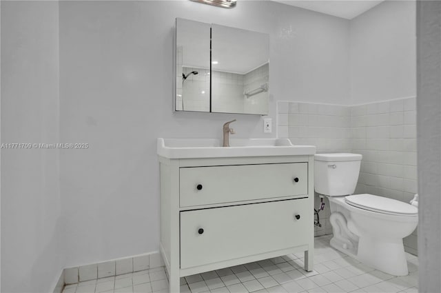 bathroom with toilet, vanity, tile patterned floors, and a shower