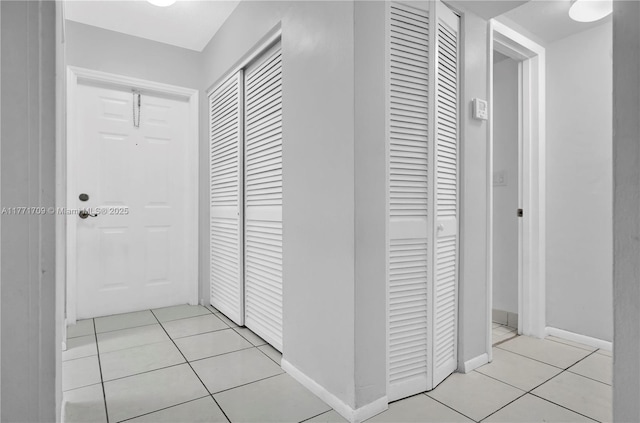 hallway featuring baseboards and light tile patterned floors