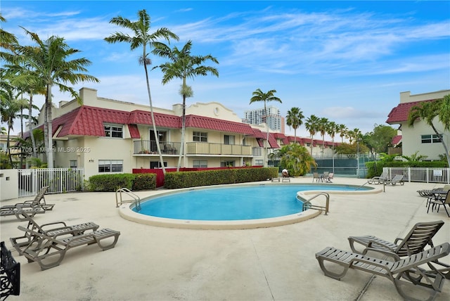 community pool featuring a patio area and fence