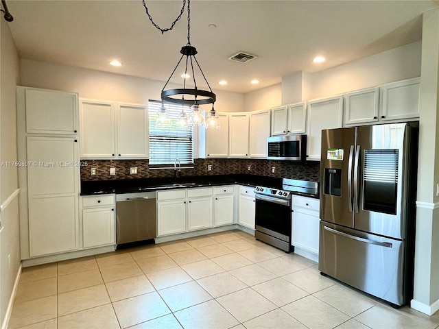 2907 Tortola Way, Cooper City, FL 33024 - kitchen featuring stainless steel appliances, dark countertops, a sink, decorative backsplash, and light tile patterned floors