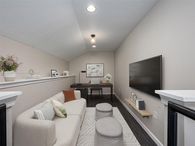 living area with baseboards, a textured ceiling, wood finished floors, and lofted ceiling