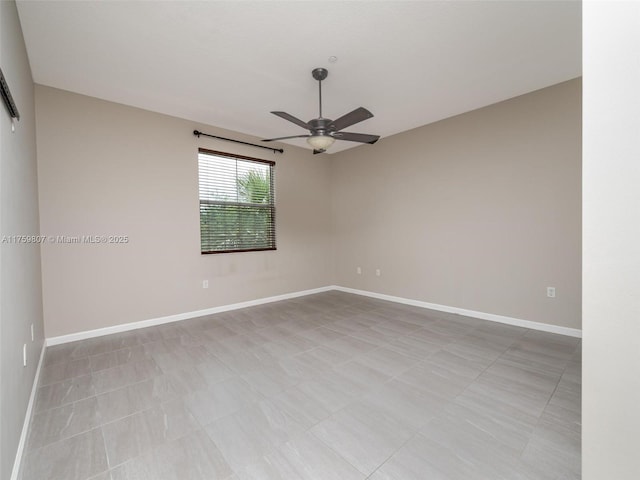 spare room with baseboards and a ceiling fan
