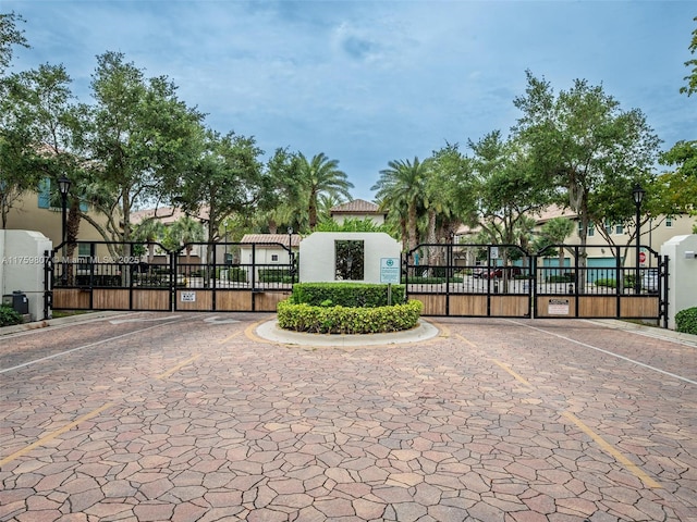 exterior space featuring a gated entry, a gate, and street lights
