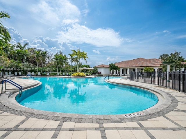 community pool with fence and a patio