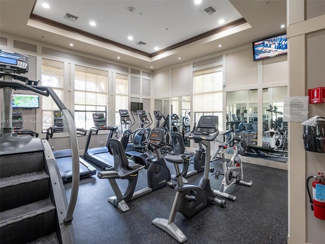 gym with visible vents and a tray ceiling