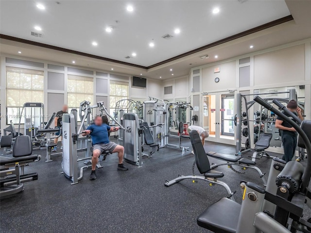 exercise room featuring ornamental molding, visible vents, recessed lighting, and a raised ceiling