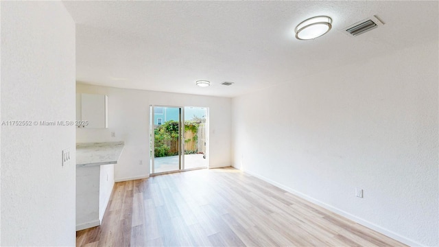 219 SW 6th Ln, Florida City, FL 33034 - unfurnished living room with baseboards, visible vents, and light wood-style floors