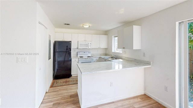 219 SW 6th Ln, Florida City, FL 33034 - kitchen with white cabinetry, visible vents, light wood-type flooring, white appliances, and a peninsula