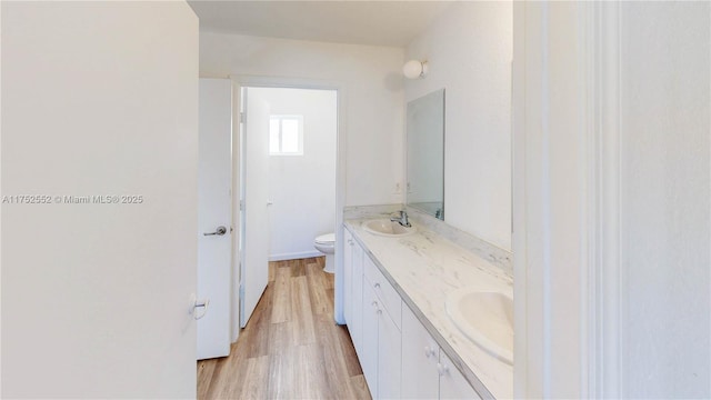 219 SW 6th Ln, Florida City, FL 33034 - bathroom with wood finished floors, toilet, double vanity, and a sink