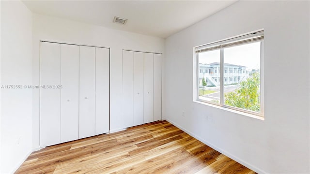 219 SW 6th Ln, Florida City, FL 33034 - unfurnished bedroom featuring baseboards, visible vents, light wood-type flooring, and multiple closets