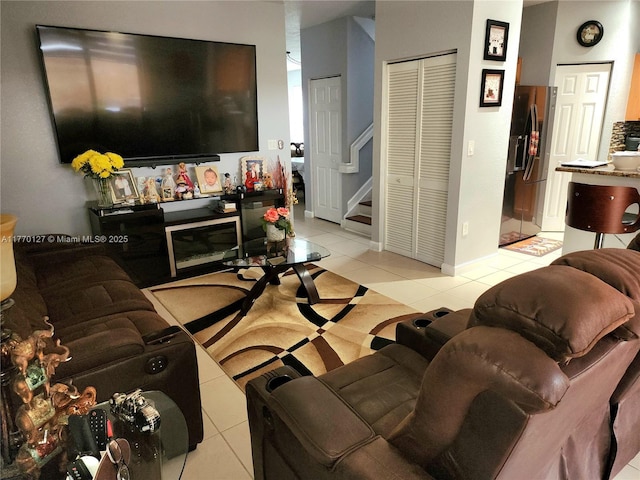 living room with baseboards, stairs, and light tile patterned floors