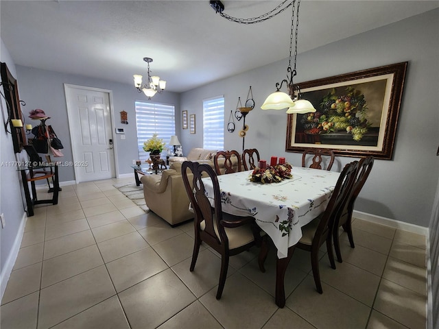 dining space featuring baseboards, light tile patterned floors, and a chandelier