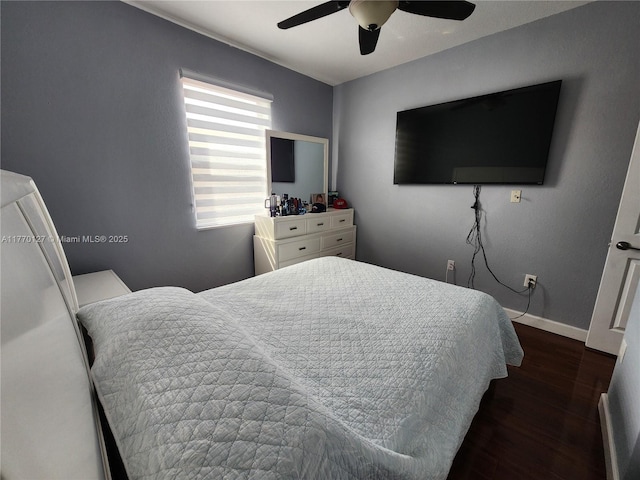 bedroom featuring baseboards, ceiling fan, and dark wood finished floors