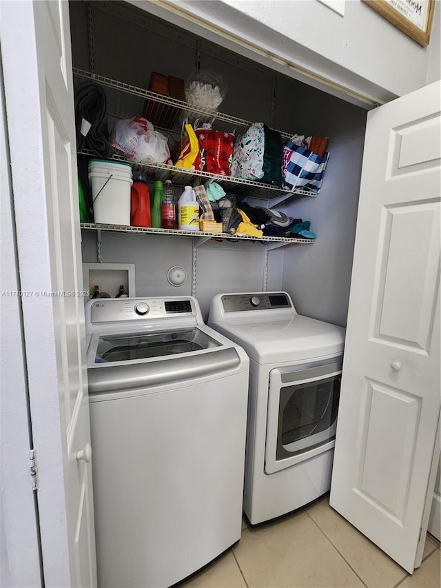 laundry area featuring washing machine and clothes dryer, laundry area, and light tile patterned floors