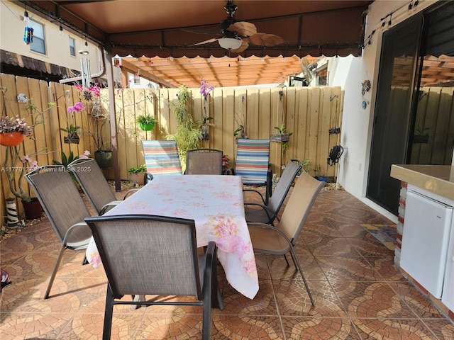 view of patio / terrace with fence, outdoor dining space, and a ceiling fan
