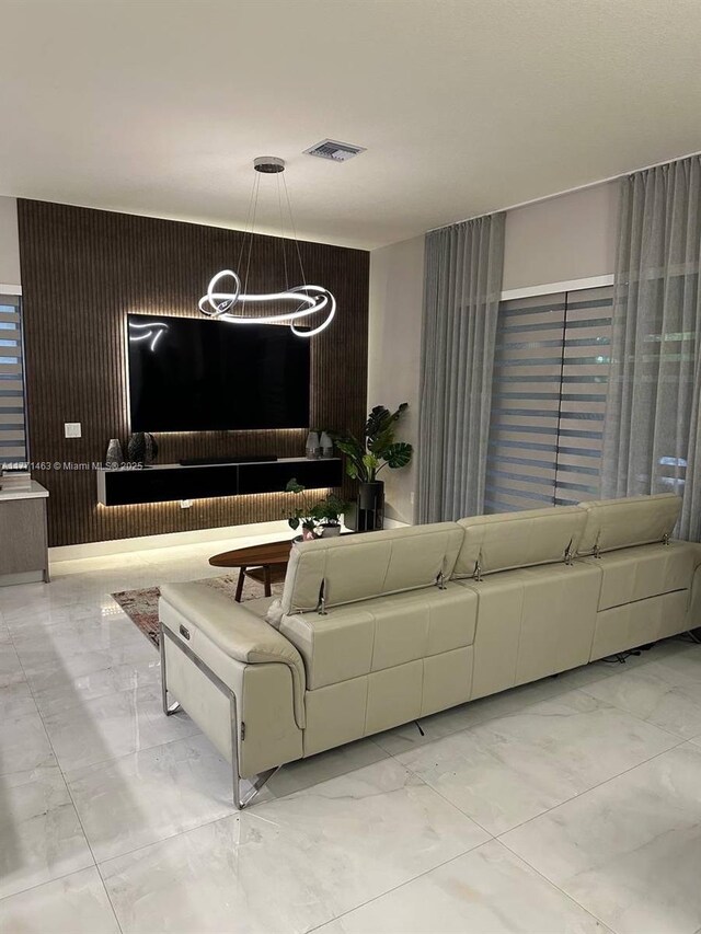 8868 NW 161st Ter, Miami Lakes, FL 33018 - living room with marble look tiles and a chandelier