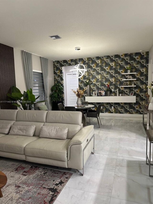 8868 NW 161st Ter, Miami Lakes, FL 33018 - living room featuring light marble finish flooring, a chandelier, and wallpapered walls