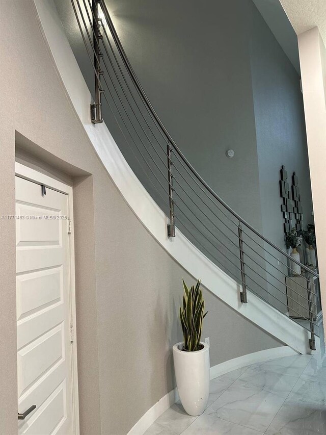 8868 NW 161st Ter, Miami Lakes, FL 33018 - stairway featuring marble look tile flooring and baseboards