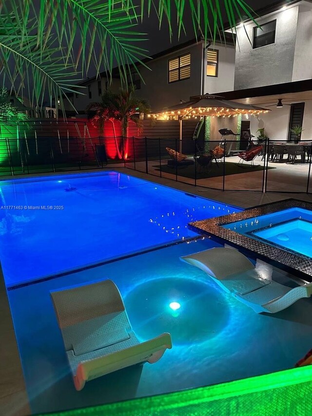 8868 NW 161st Ter, Miami Lakes, FL 33018 - pool at night with an in-ground hot tub and a patio