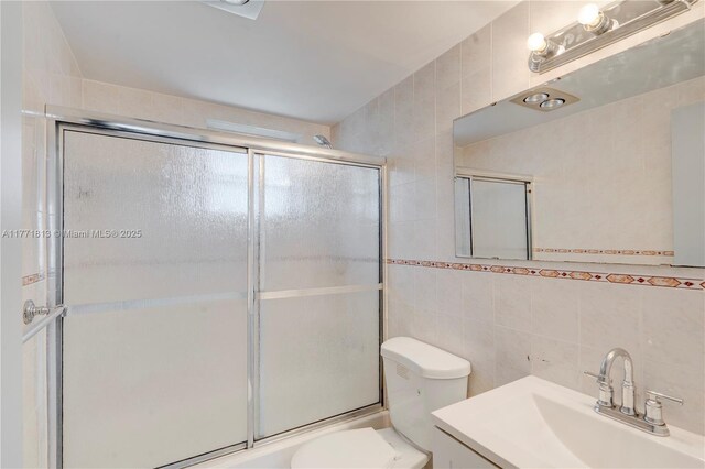 6288 SW 22nd Ct, Miramar, FL 33023 - bathroom with tile walls, toilet, shower / bath combination with glass door, and vanity