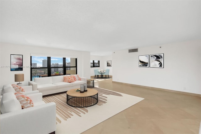living area with a city view, baseboards, and visible vents
