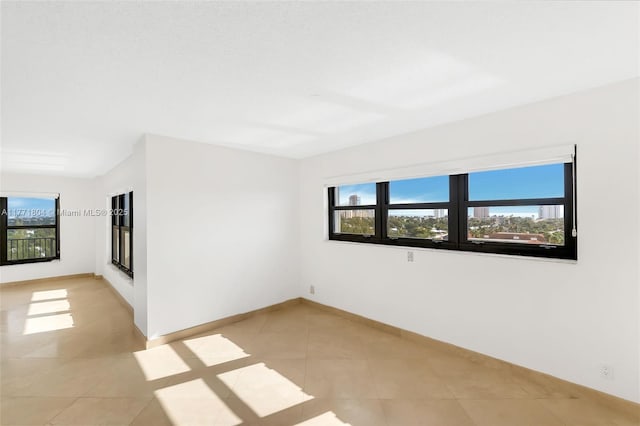 unfurnished room featuring light tile patterned floors and baseboards