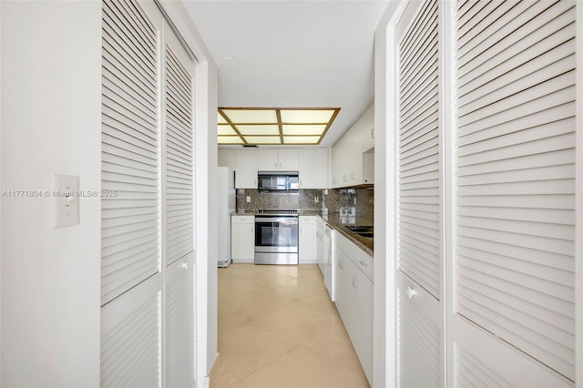 hall featuring light tile patterned flooring and baseboards