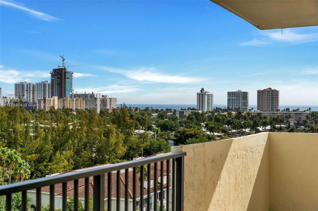 balcony with a water view and a view of city