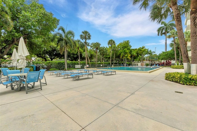 community pool with fence and a patio area