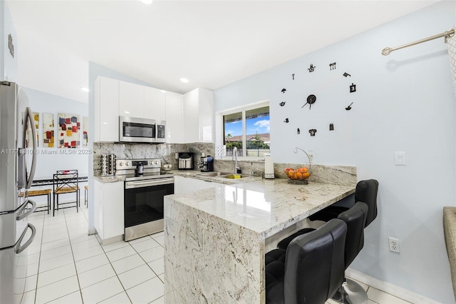 15317 SW 179th Ter, Miami, FL 33187 - kitchen with decorative backsplash, a peninsula, stainless steel appliances, a sink, and light tile patterned floors