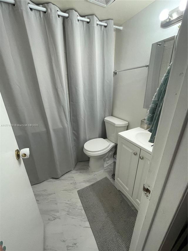 full bath with toilet, marble finish floor, vanity, and curtained shower