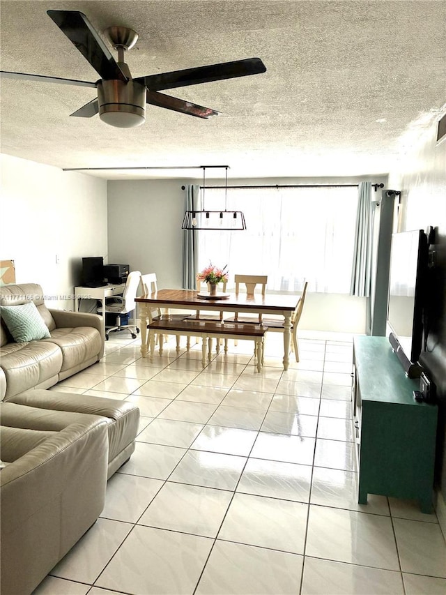 living room featuring ceiling fan and a textured ceiling