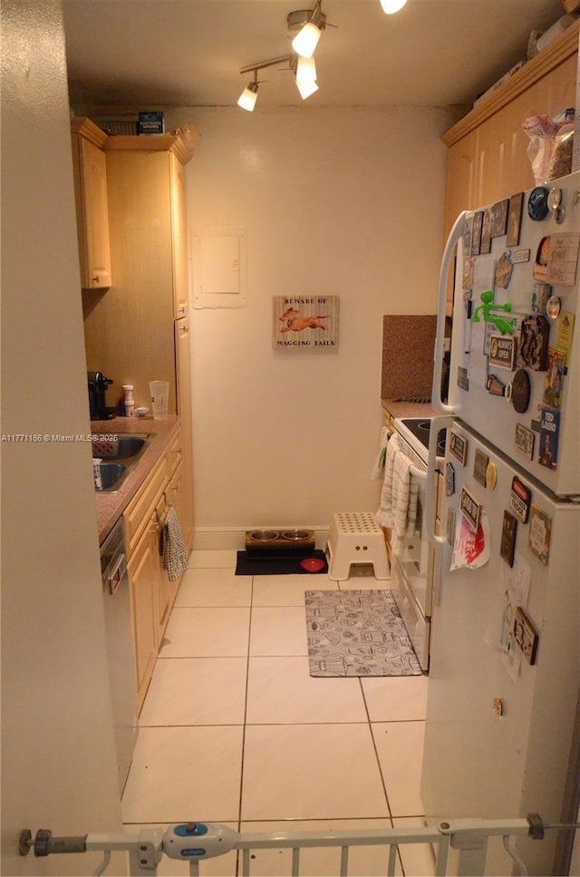 kitchen featuring white appliances, light countertops, light tile patterned flooring, and a sink