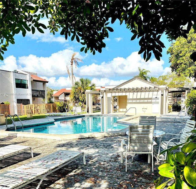 community pool with fence, a patio, and a pergola