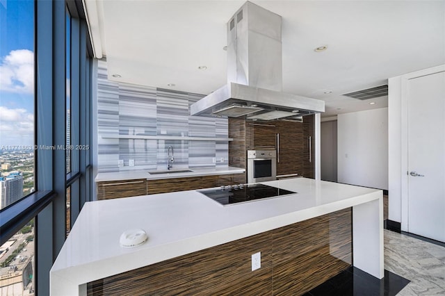 1100 Biscayne Blvd Unit 4901, Miami, FL 33132 - kitchen featuring black electric cooktop, modern cabinets, island range hood, oven, and light countertops