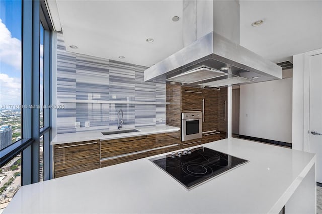 1100 Biscayne Blvd Unit 4901, Miami, FL 33132 - kitchen featuring island range hood, black electric cooktop, stainless steel oven, modern cabinets, and tasteful backsplash