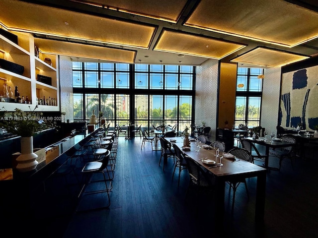 1100 Biscayne Blvd Unit 4901, Miami, FL 33132 - dining area featuring a community bar, a high ceiling, wood finished floors, and a wall of windows