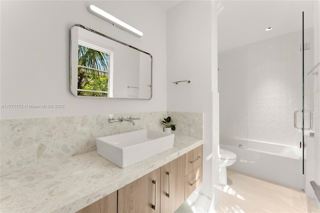 bathroom featuring bathtub / shower combination, toilet, vanity, tile patterned flooring, and decorative backsplash