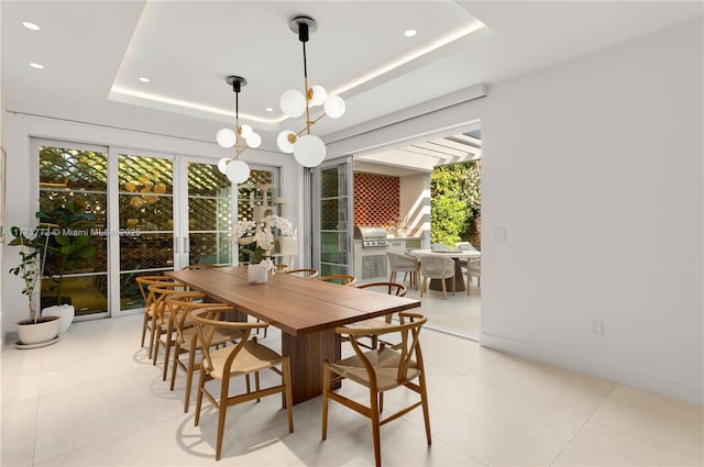 dining room featuring light tile patterned floors, a tray ceiling, recessed lighting, and a notable chandelier