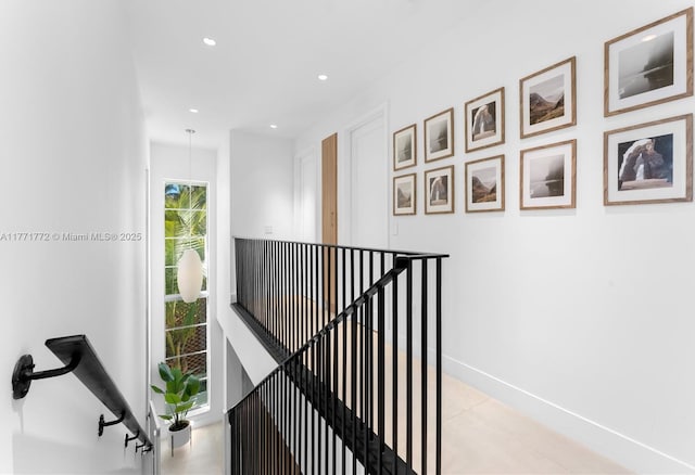 hallway featuring an upstairs landing, baseboards, and recessed lighting