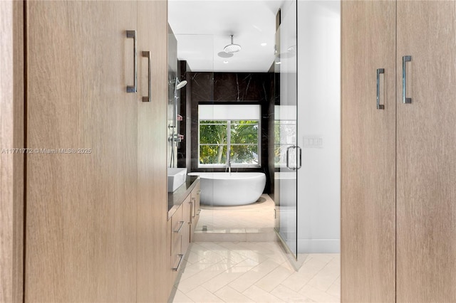 full bathroom featuring a shower stall, tile patterned floors, a soaking tub, and vanity